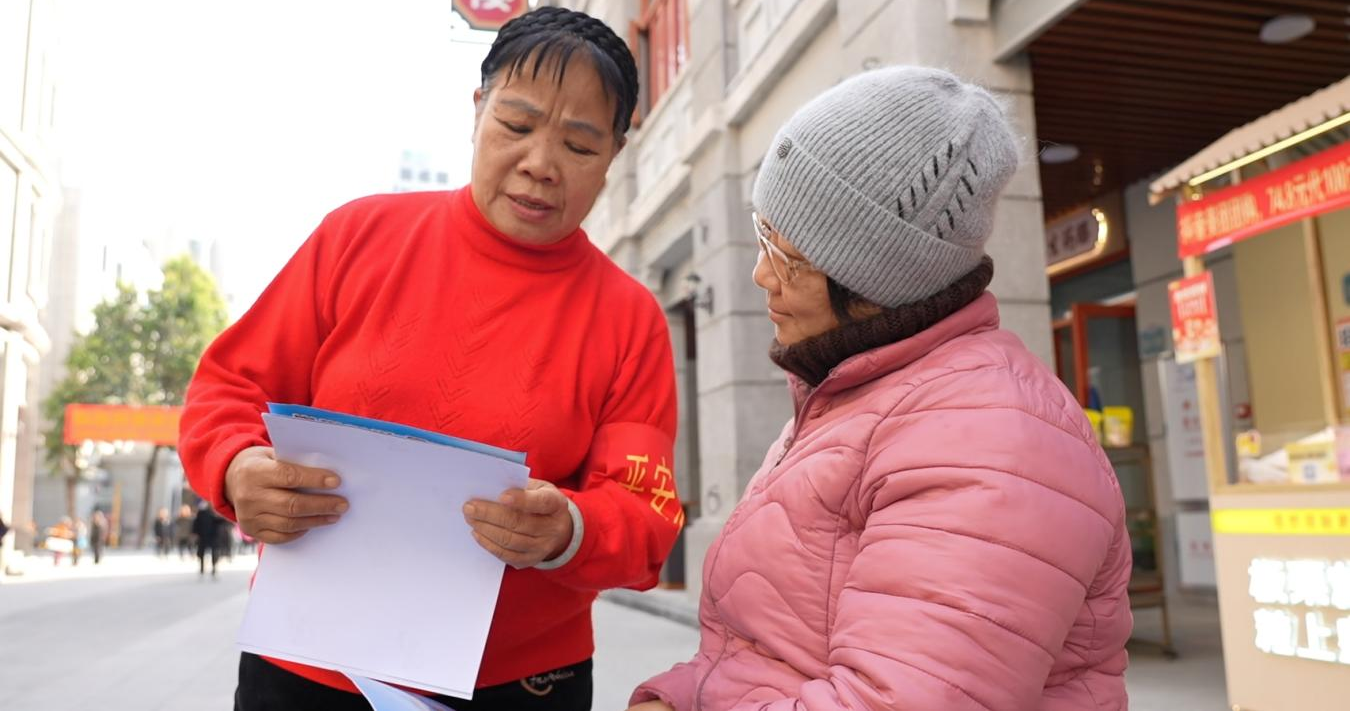 “骑楼大妈”黄冰晶在骑楼城向游客开展反邪教宣传(龙燕媚 摄)