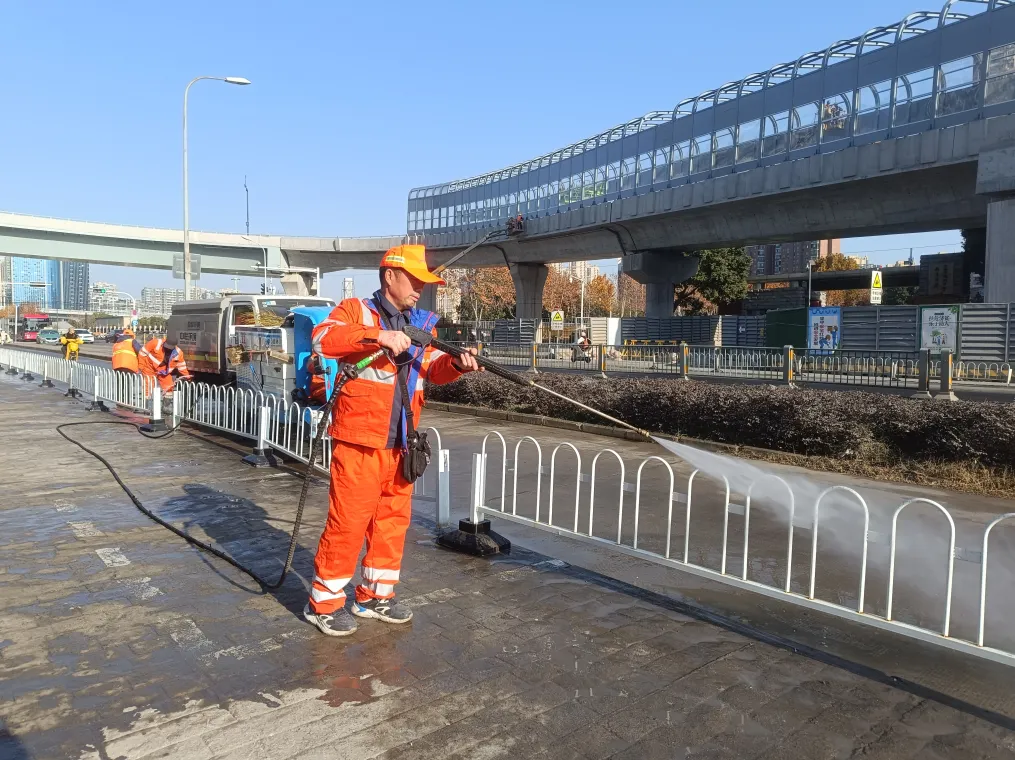 在合肥西站附近的潜山路上,环卫工人正在进行冲洗作业(宗雷 摄)