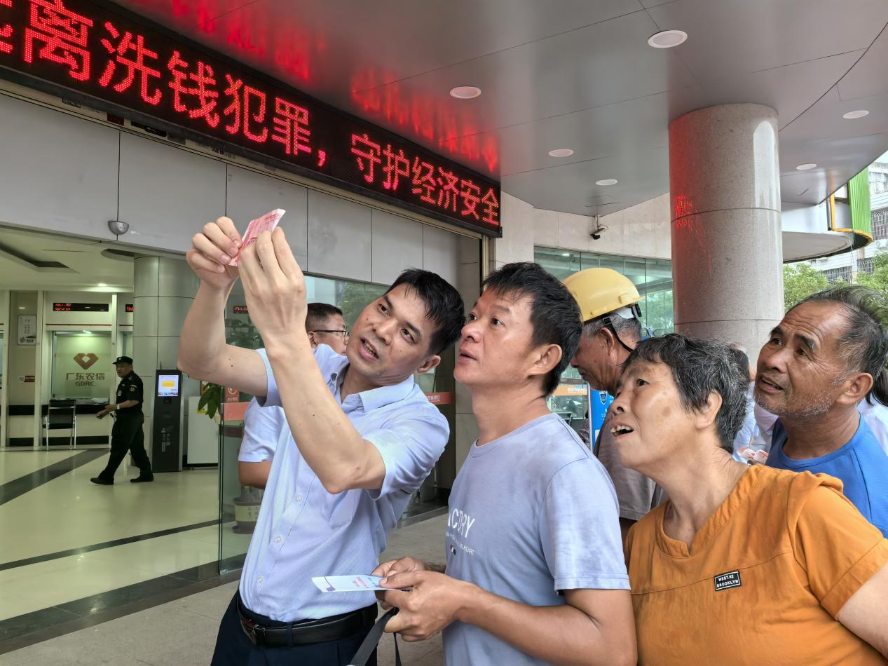 罗定农商银行工作人员向群众普及金融知识 (招桂英 摄) 配图2