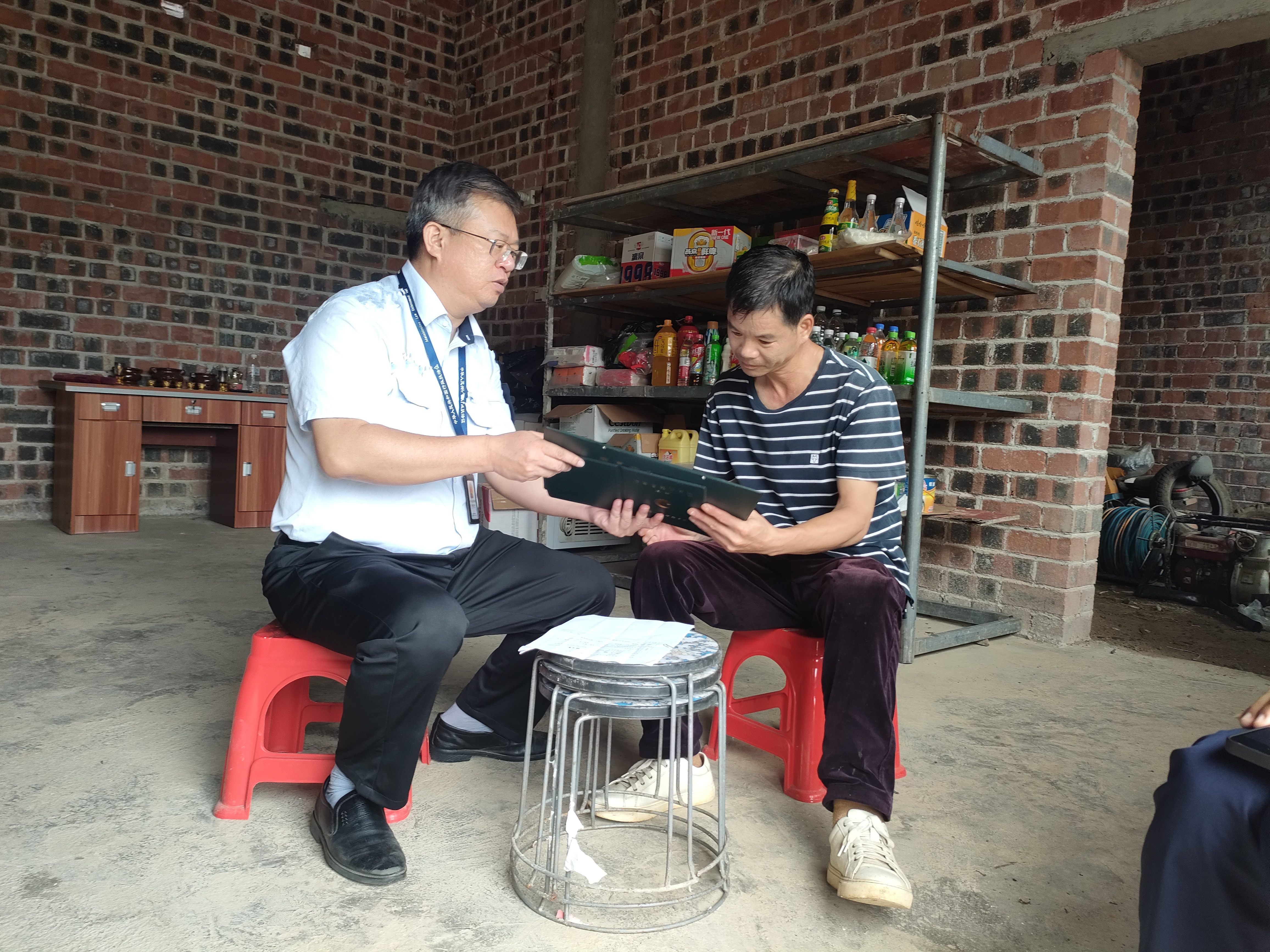 崇左烟草基层所(站)执法人员向偏远地区群众提供“许可证上门服务”(李志海 摄)