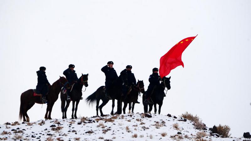 2026年元旦,新疆阿克苏边境管理支队阿克青边境派出所的民警与护边员们骑马踏雪巡边,在山巅向祖国敬礼。(赵新昌 摄)