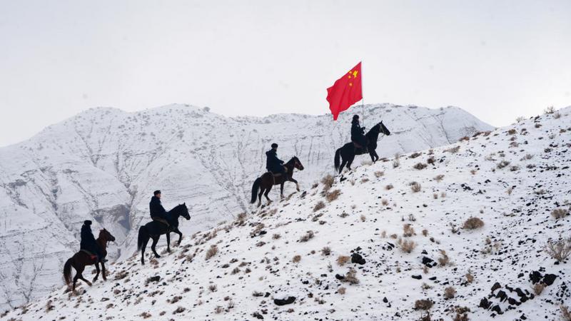 新疆阿克苏边境管理支队阿克青边境派出所的民警与护边员们骑马踏雪巡边(赵新昌 摄)
