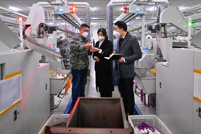 仁寿经开区工作人员在四川省仁寿县金鹅纺织有限公司生产车间了解企业生产销售及惠企政策落实情况 (文潘帅 摄)