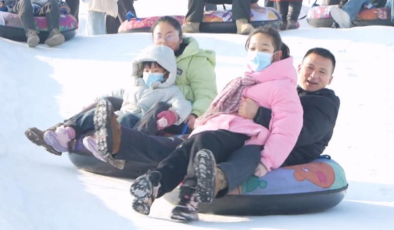 活动现场,家长们正带着孩子一起体验冰雪运动的快乐。(帕孜丽亚·托乎尼亚孜 摄)