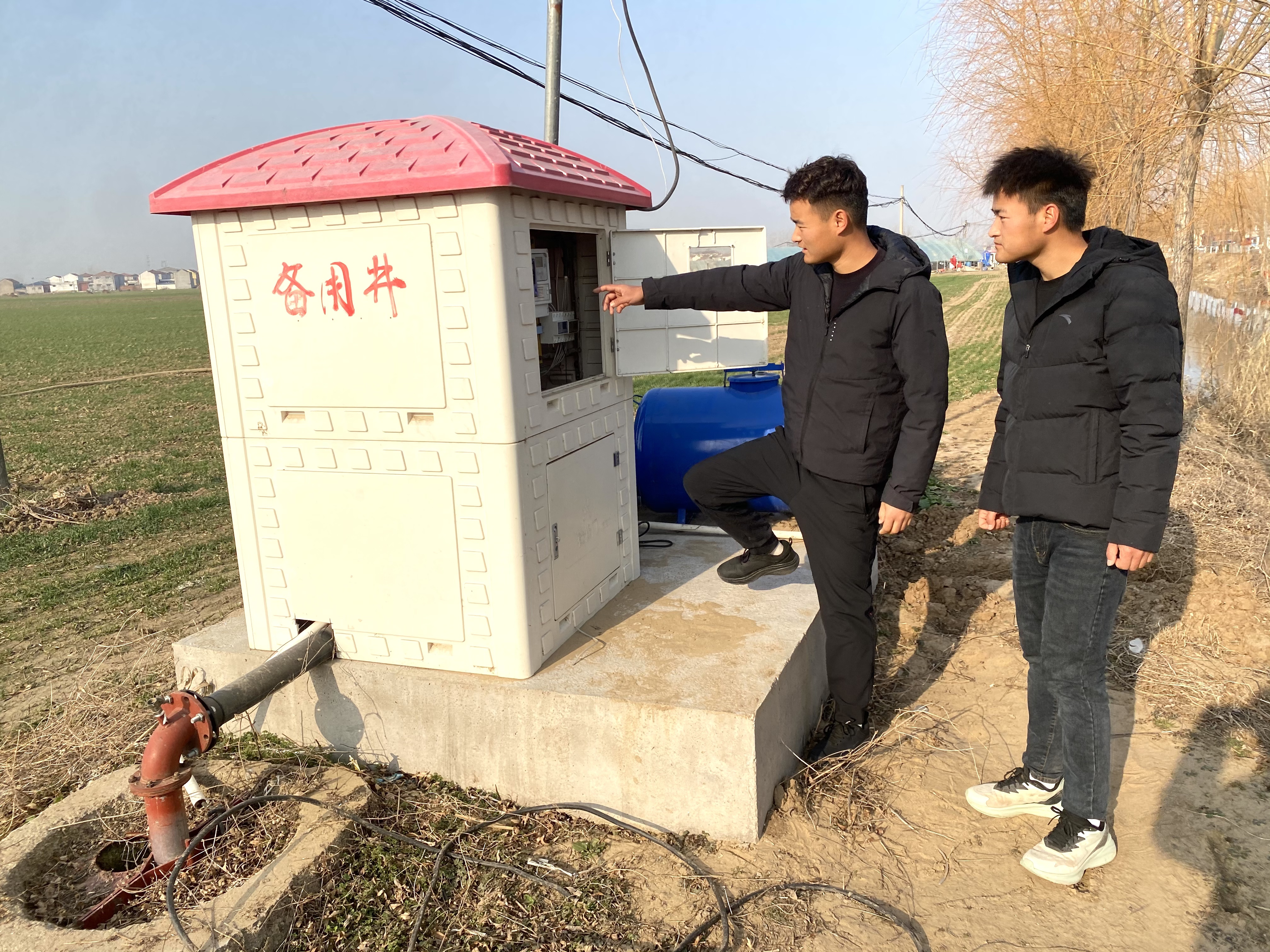 王立明(右)、王路明查看水肥一体化技术灌溉设备(赵永昌 摄)