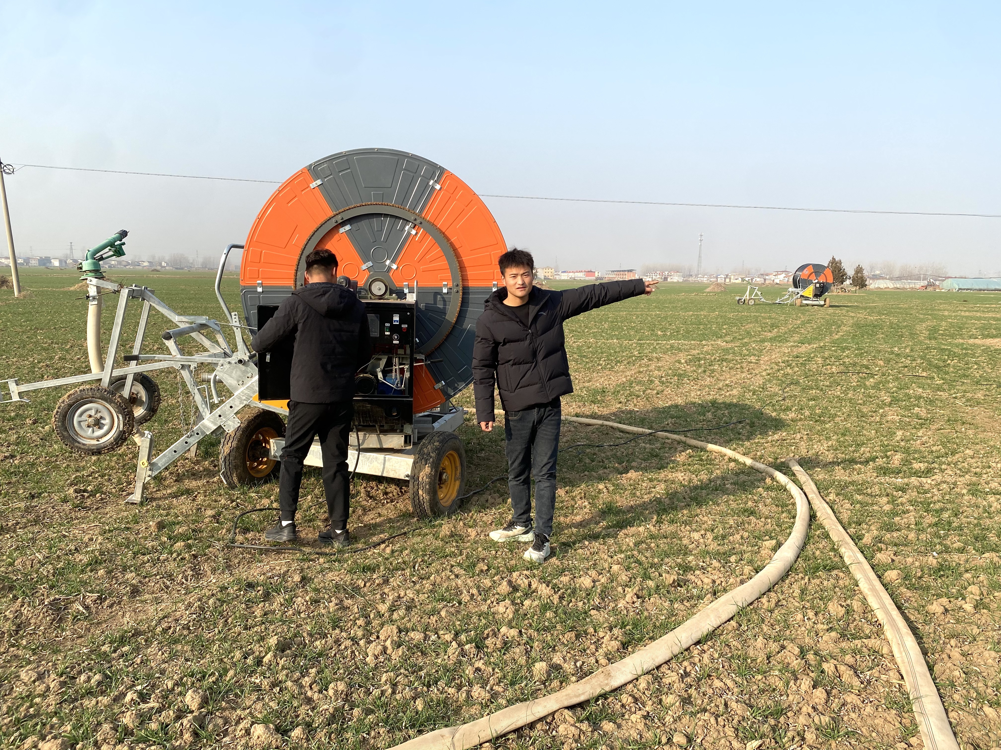 王立明(右)、王路明整理卷盘式喷灌机(赵永昌 摄)