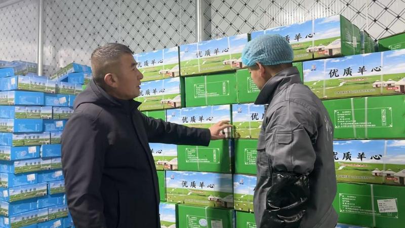 贾晓伟(左一)检查包装完的羊肉产品 ( 高默含 摄)