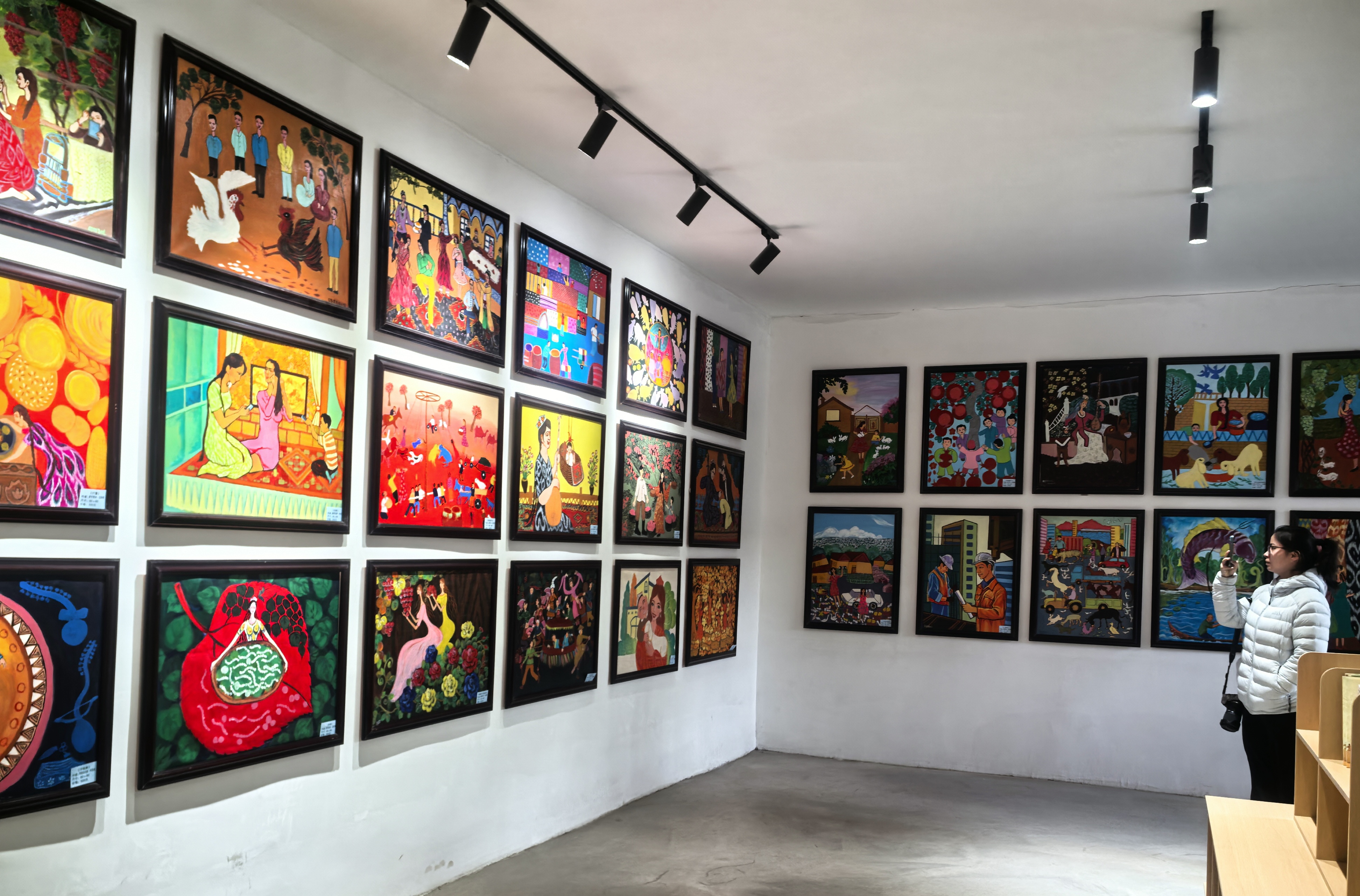 游客在阿瓦提县刀郎文化(农民画)非遗传承中心欣赏农民画作品(查燕荣 摄)