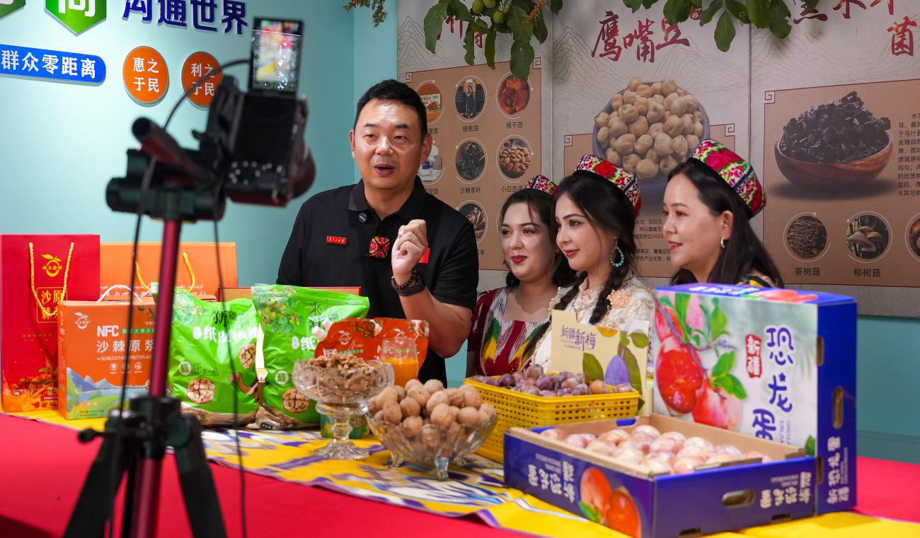 驻村第一书记朱星儒与本土年轻主播在直播介绍农产品(史启发 摄)