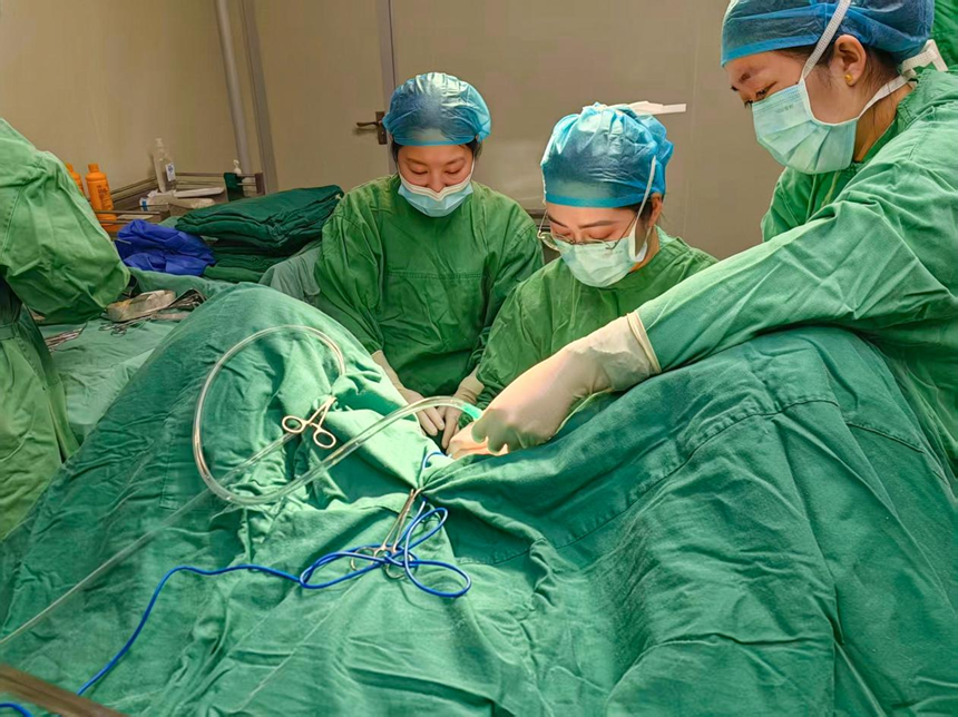 蒋可(右二)正在为患者实施手术。(潘政吉 摄)
