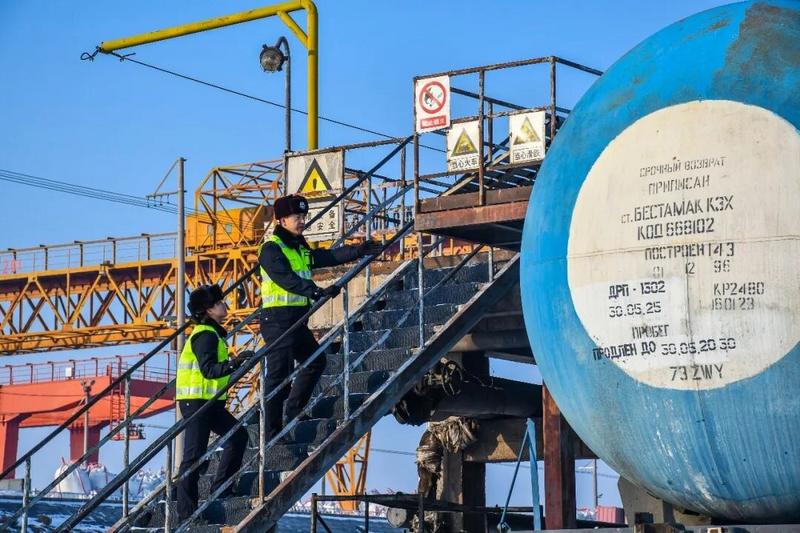 民警登上罐车作业梯,对列车进行安全检查。(张瑾瑜 摄)