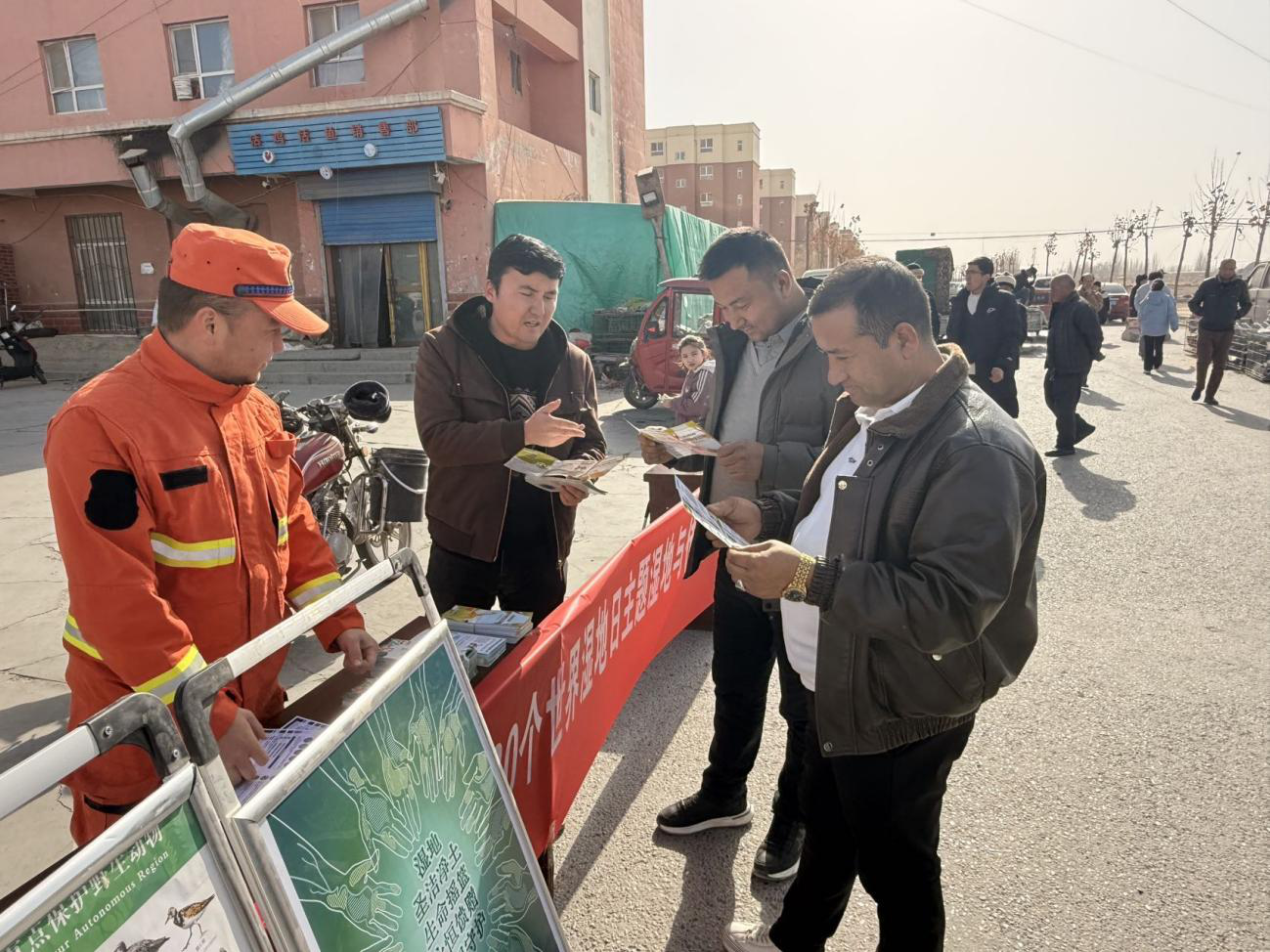 工作人员向过往群众发放宣传手册(艾买江·尼亚孜 摄)