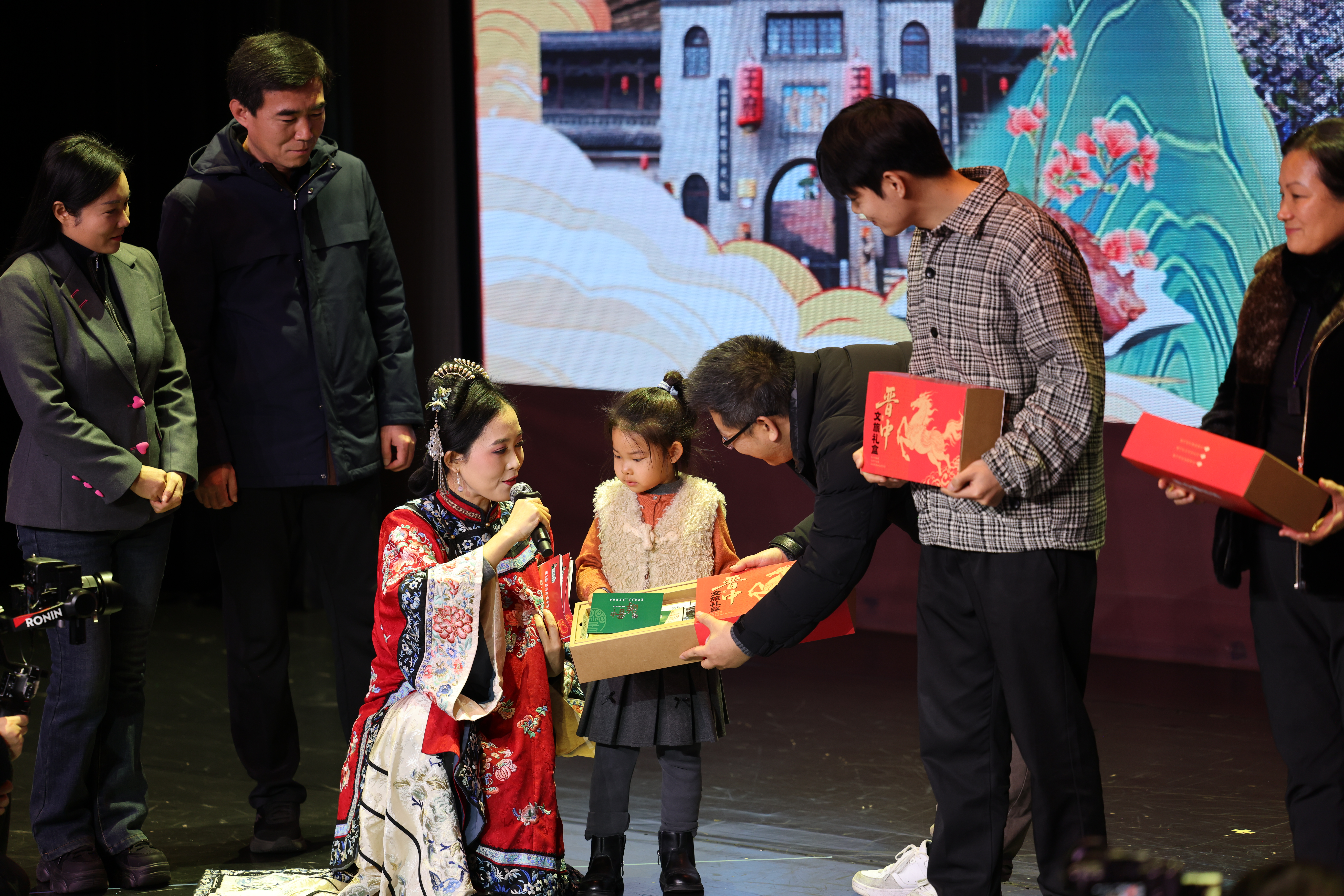 晋中文旅推介现场,工作人员向小朋友赠送礼盒(席兆平 摄)