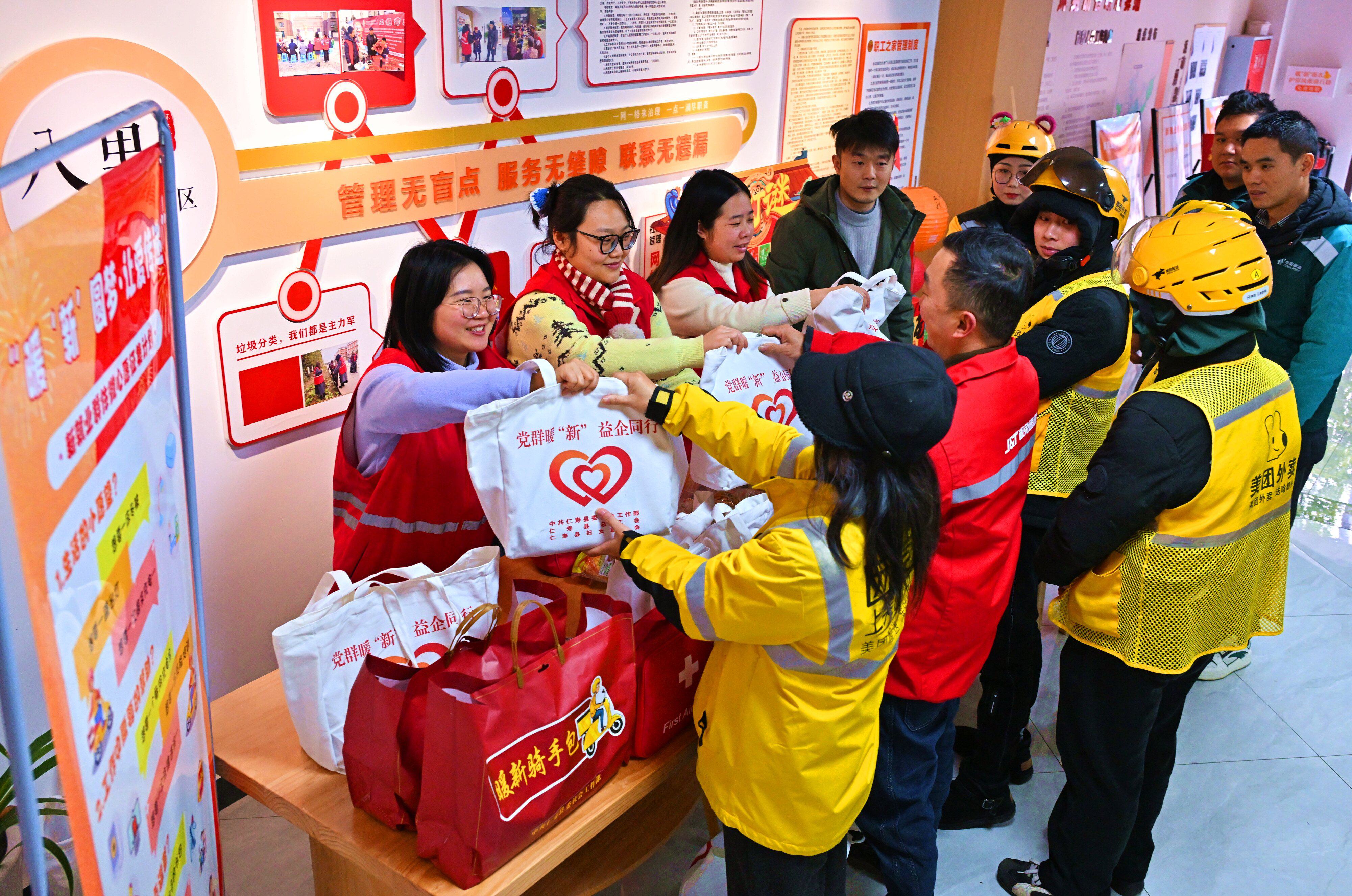 在仁寿县怀仁街道,县委社会工作部、总工会的工作人员正在集中为辖区的新就业群体暖心礼包。(潘帅 摄)