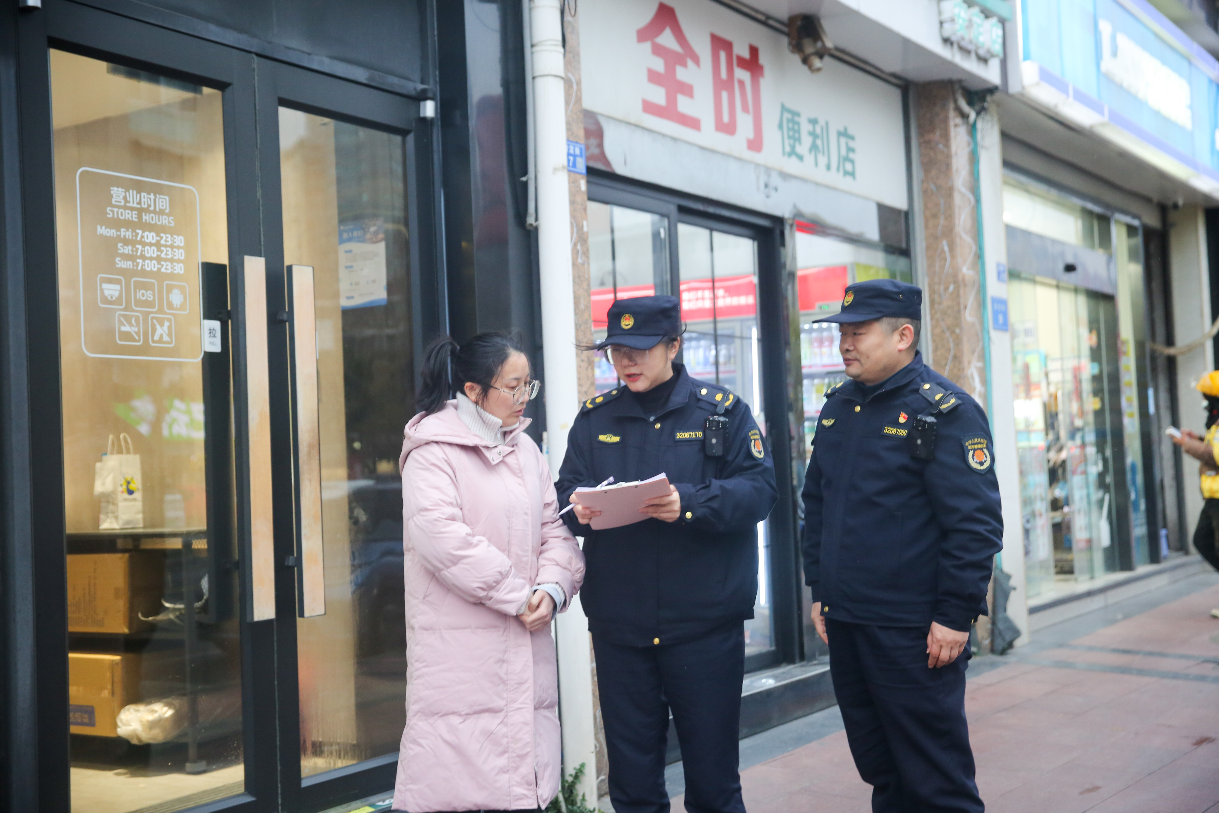 工作人员发放《沿街商铺市容环卫责任告知书》(徐慧 摄)