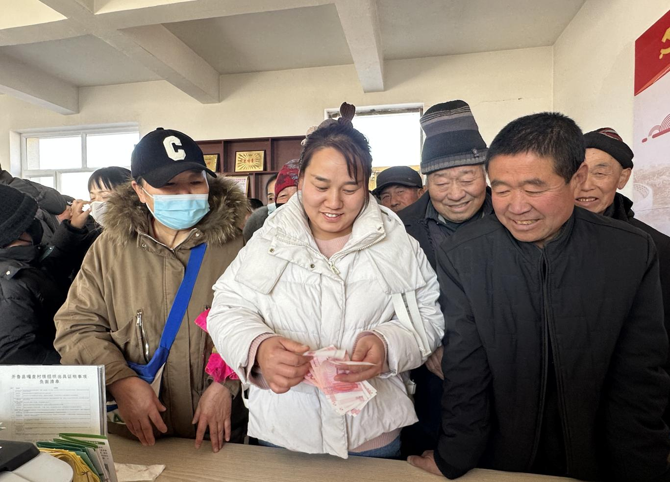 领到补贴的村民,满脸喜悦。(李潇 摄)