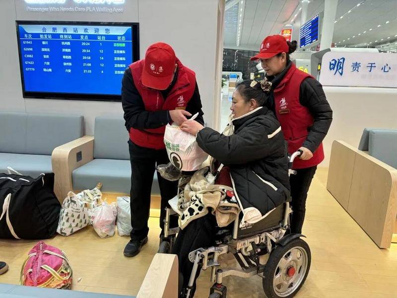 志愿者为行动不便的旅客搬运行李物品(许丽丽 摄)
