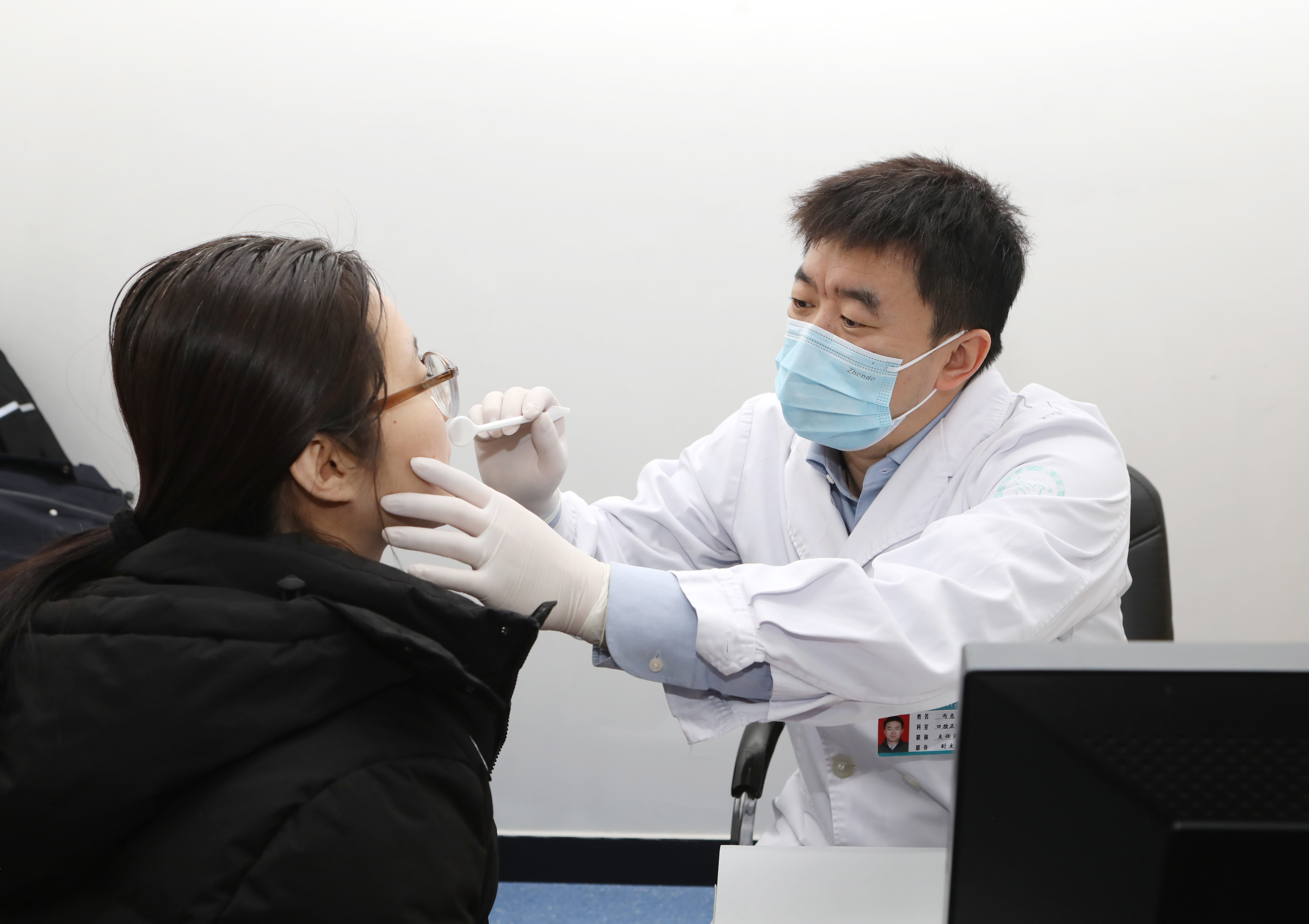 专家在义诊现场为群众细致问诊(白富文 摄)