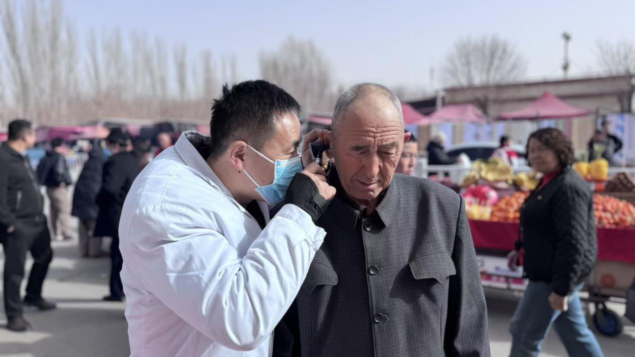 工作人员正在免费为老人义诊(古丽迪雅尔·艾尼瓦尔摄)