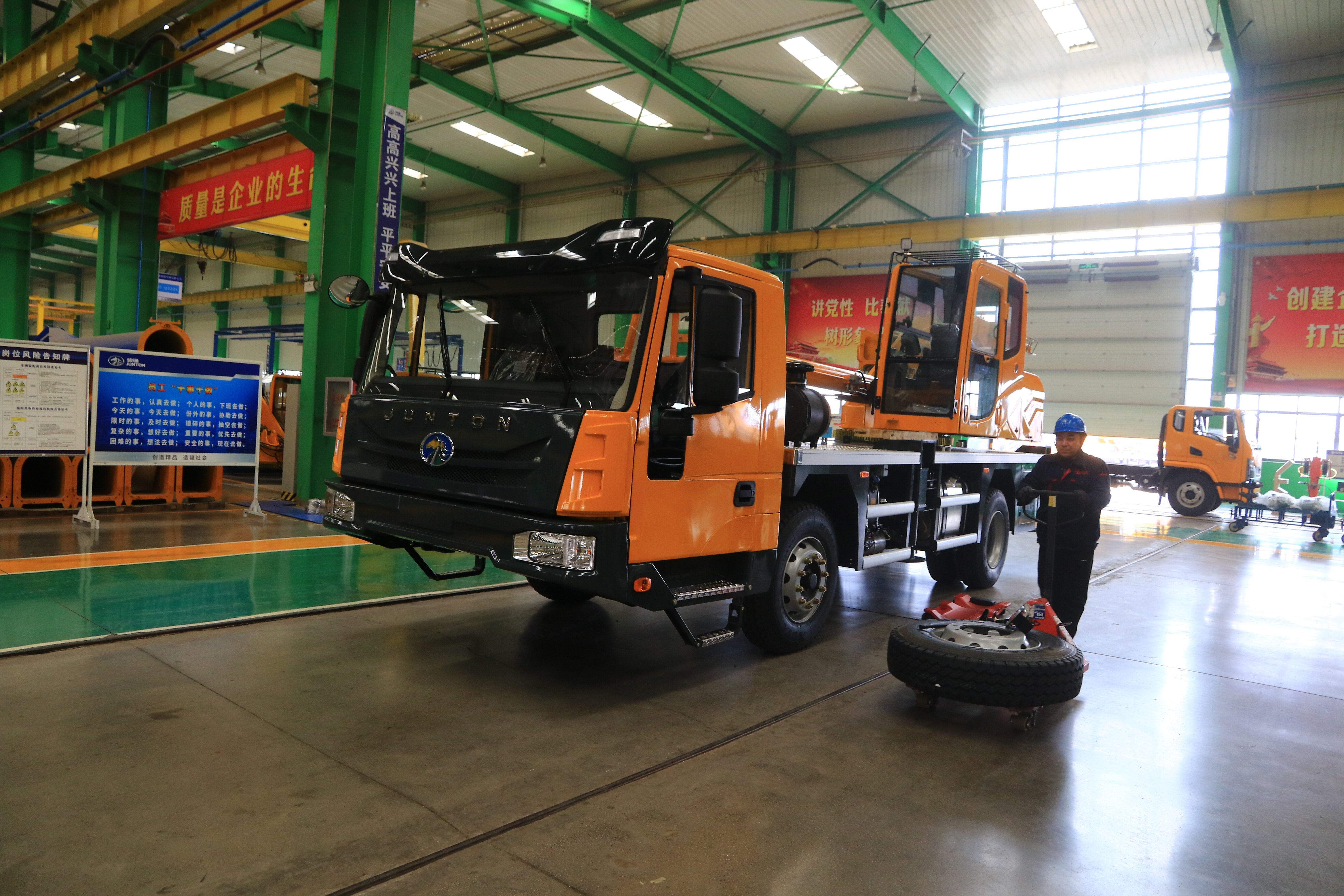 河南骏通车辆有限公司生产车间,工人准备安装轮胎。(王建栋 摄)