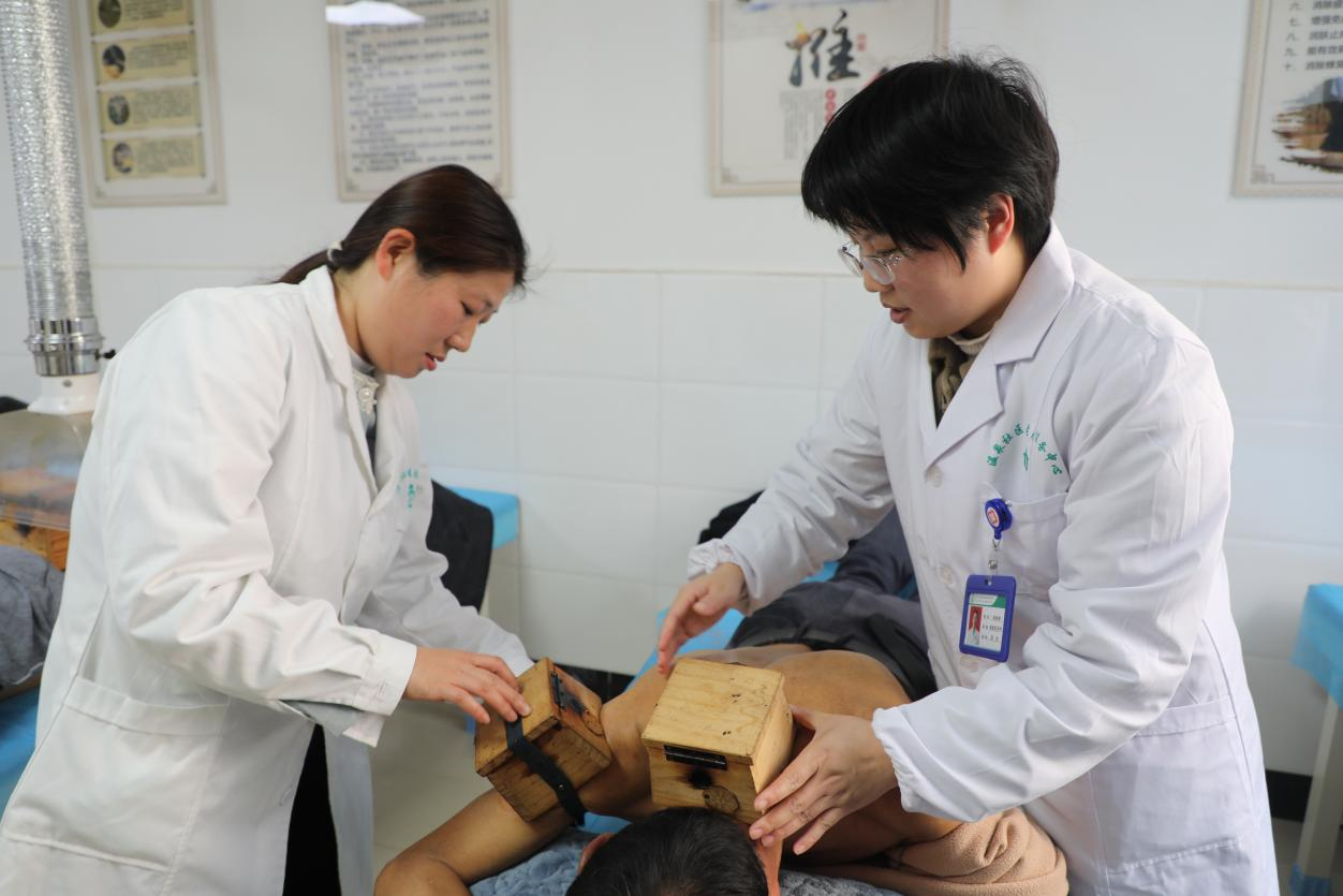 方萍(左)跟随带教老师练习艾灸(刘钊海 摄)