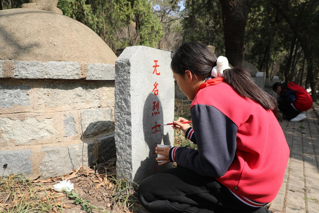 少先队员代表为褪色烈士墓碑描红(滕怀超 摄)