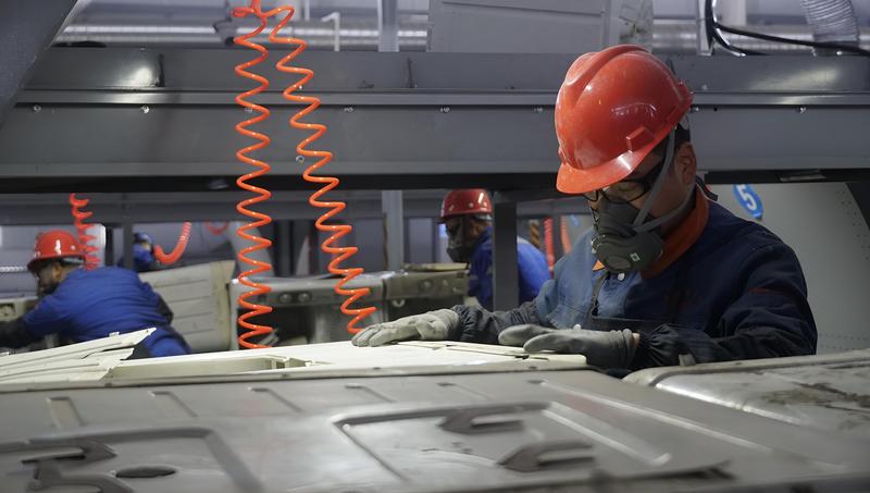 一名工人正在生产线上拆解废旧洗衣机 (冶梓杰 摄)