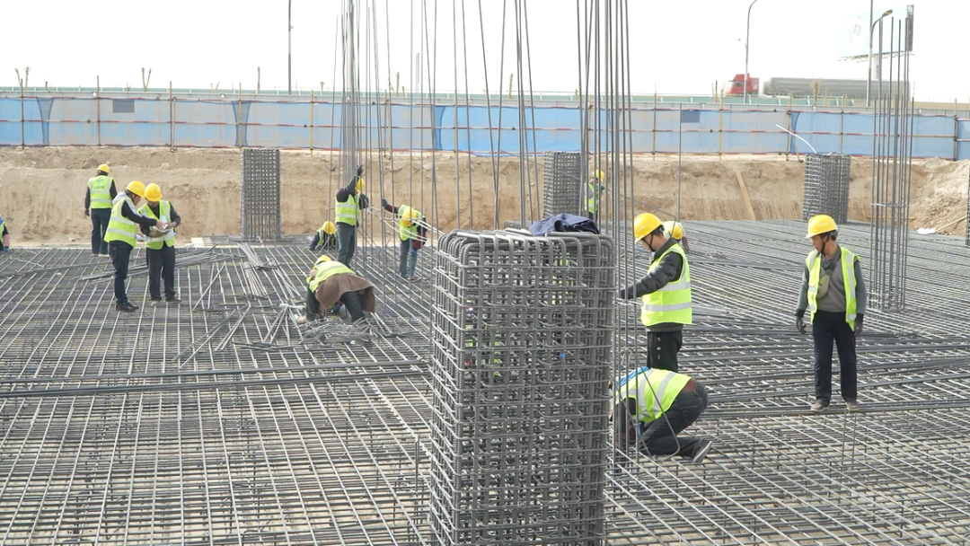 项目建设现场,工人们正分工协作、紧张作业,有条不紊地推进新厂房及配套设施建设。(张勇 摄)