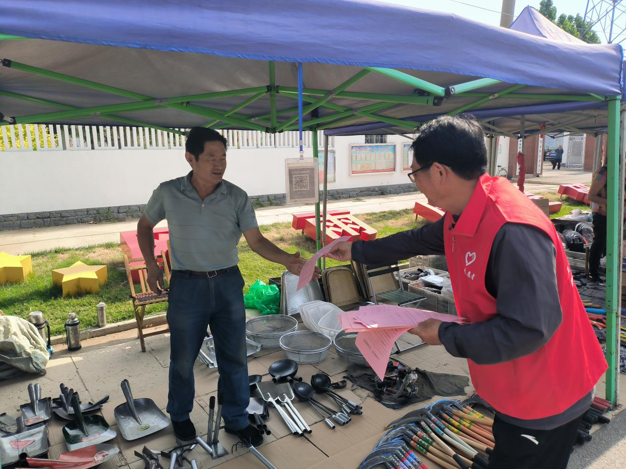 送政策到摊位(张安琪 摄)