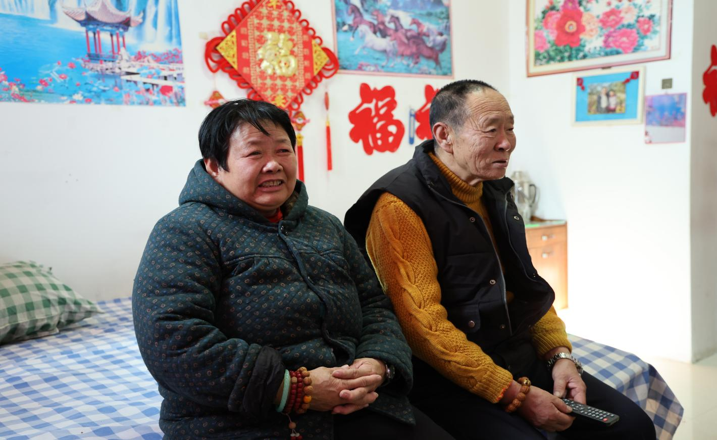 李长树(右)和老伴儿在房间看电视(邵云哲 摄)