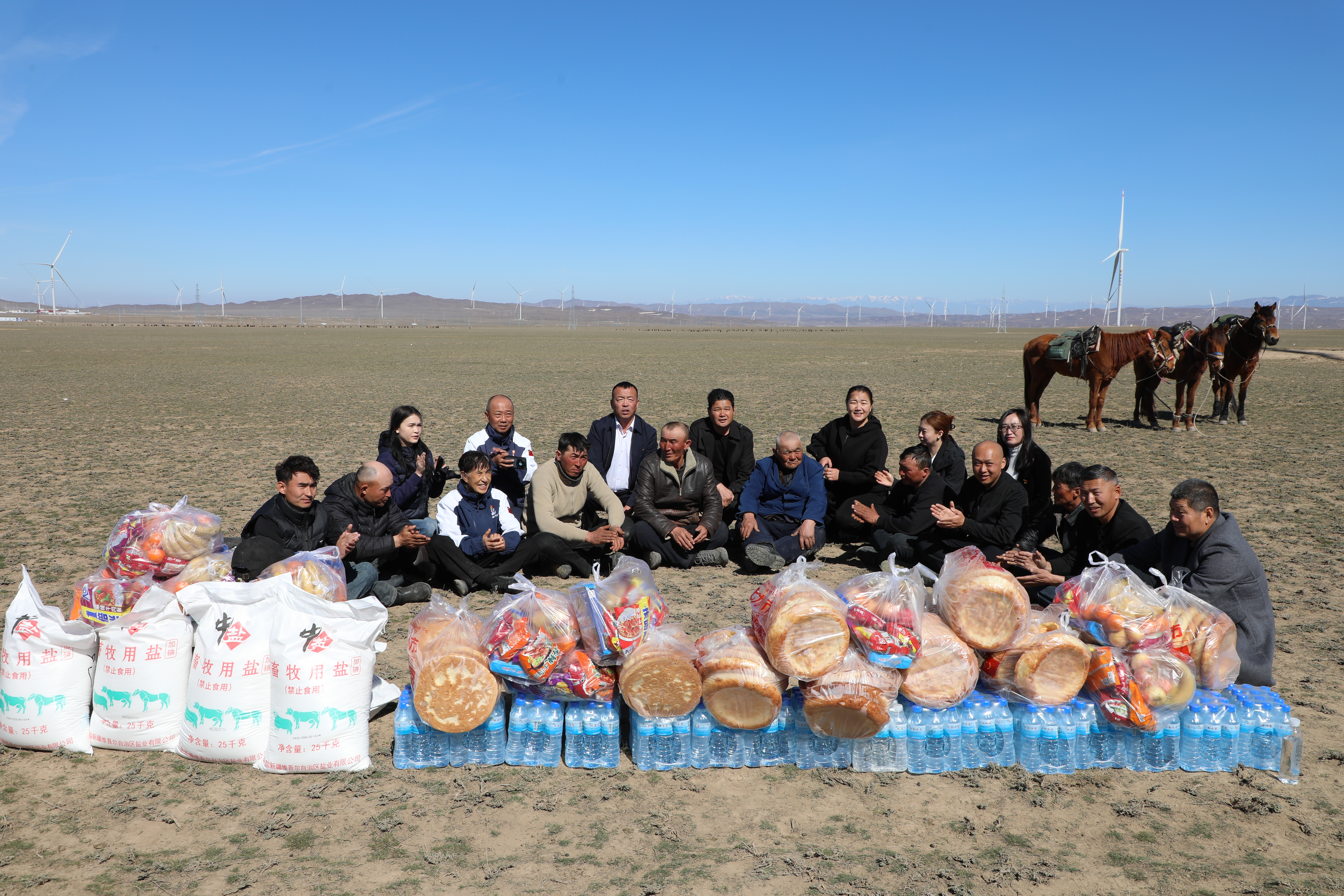 “暖心客”为牧民们送上了食盐、馕、矿泉水、水果、手抓饭等生活用品(柳鹏 摄)