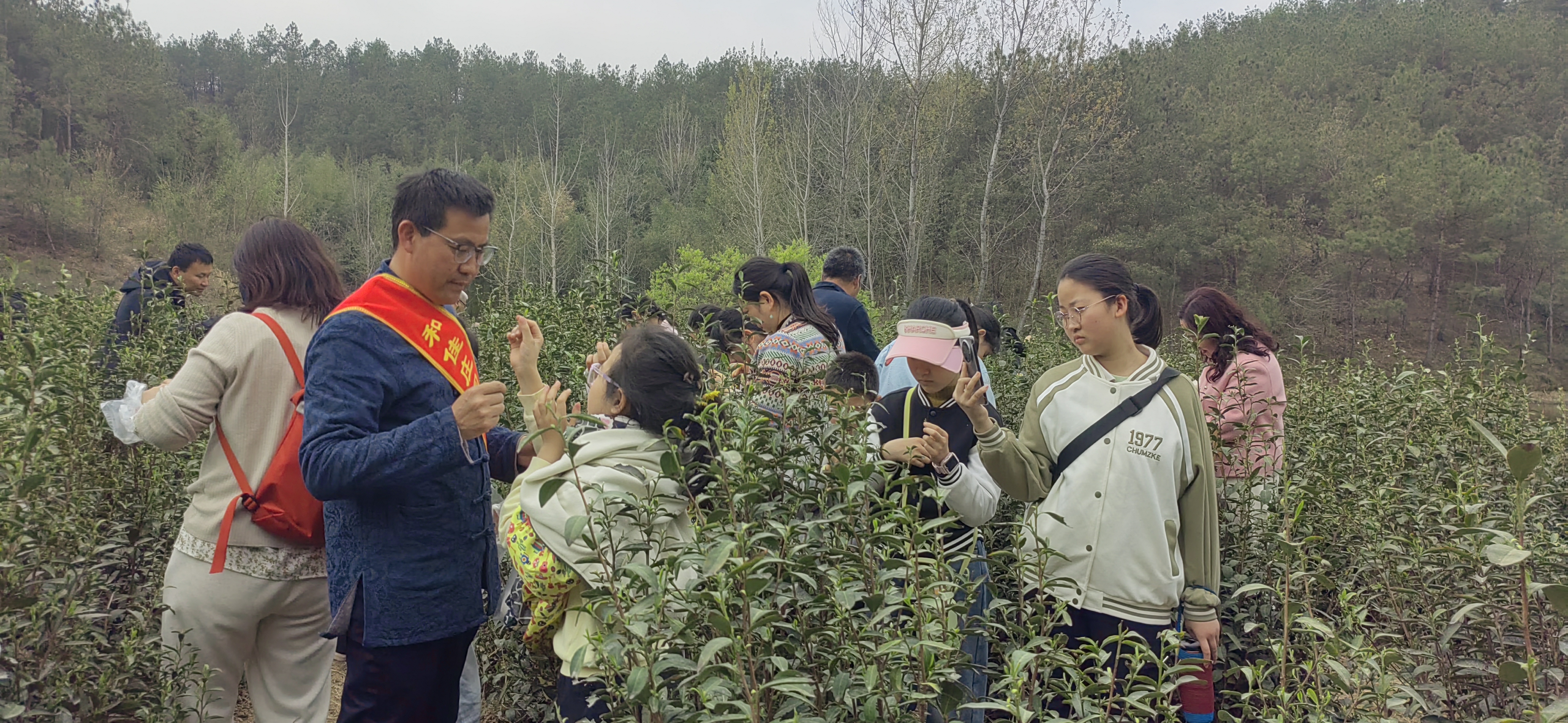 刘可佳(左三)向青少年普及茶叶种植与采摘知识(杜福建 摄)