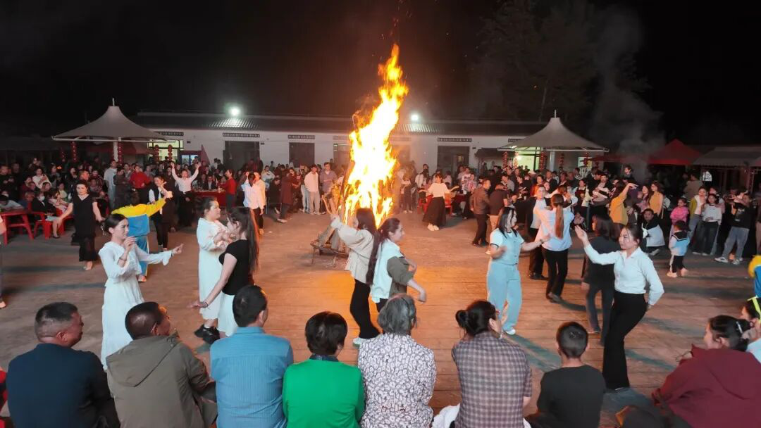 在篝火夜市,当地群众和游客载歌载舞。(阿依古力·吐尼亚孜 摄)