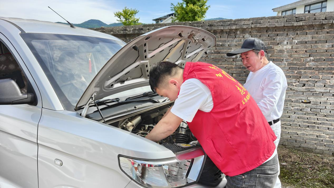 石义锋帮助游客修车(刘伊 摄)