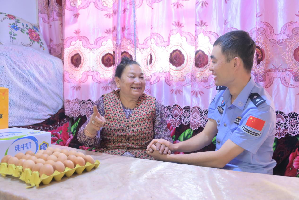 阿克苏边境管理支队塔格拉克边境派出所的民警郝文彬看望独居老人(李世林 摄)
