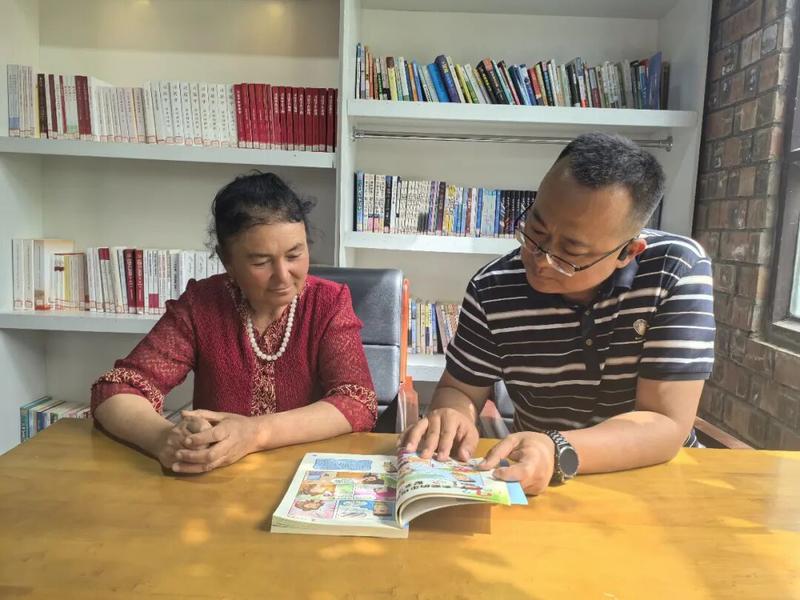 地委宣传部干部在文化大院阅览室与村民共读书籍、同读一本书,在书香中传递民族团结正能量。(殷莉蓉 摄)