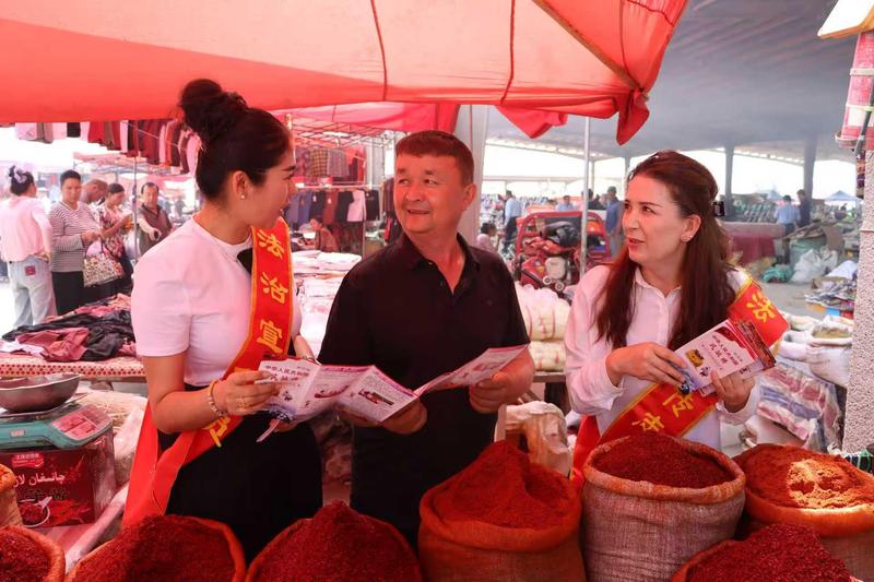 温宿县司法局工作人员走进巴扎,为商户普及民法典、经营维权等法律常识(张静 摄)