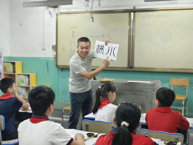 在“秀·星光”叶鉴贤名师工作室,学生在老师认真指导下揣摩笔画、研习笔法。(谭庆莲 摄)