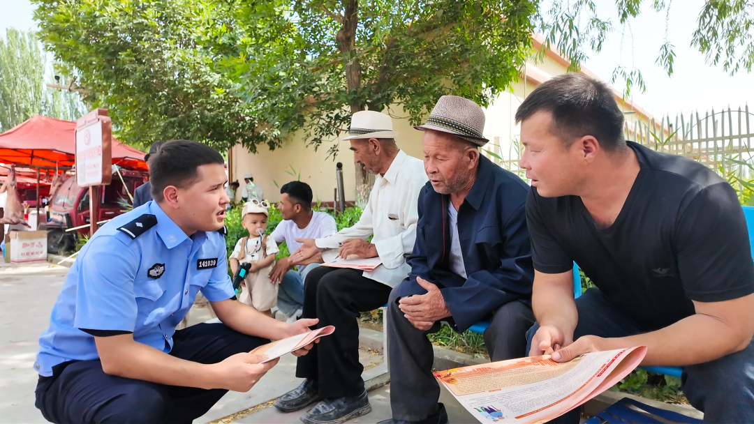 县公安局法制大队民辅警在乡镇集市宣传民法典场景(艾尼卡尔江·艾合买提 摄)