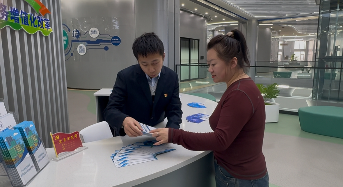 桦南县营商环境建设监督局党员示范岗工作人员为群众发放办事指引(高可琪 摄)