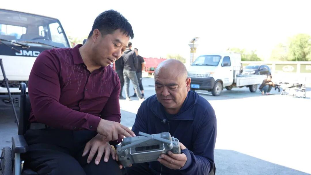 陈力锋给农户讲解无人机使用情况(王耀伟 摄)