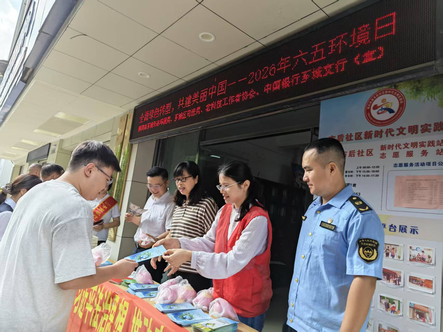 在市后社区便民咨询台,志愿者向居民发放手册、解答环保等相关问题。(黄乐 摄)