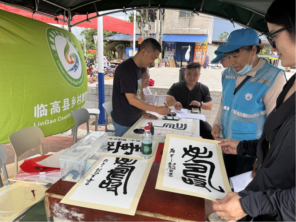 诗词楹联爱好者挥毫泼墨,将寓意吉祥的书法作品赠予长者。(陈奇巧 摄)