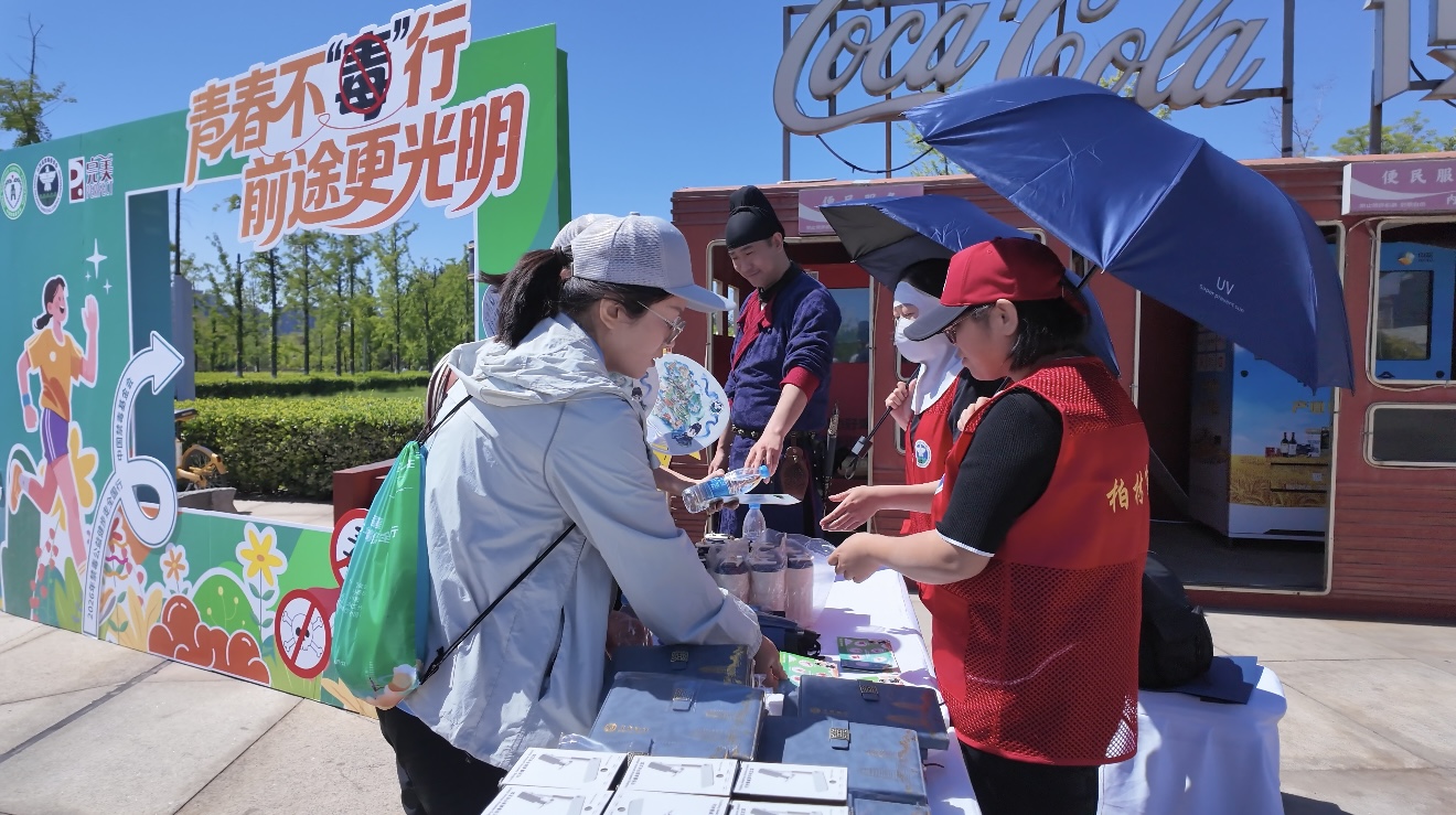志愿者完成禁毒互动打卡后领取纪念品 (席兆平 摄)
