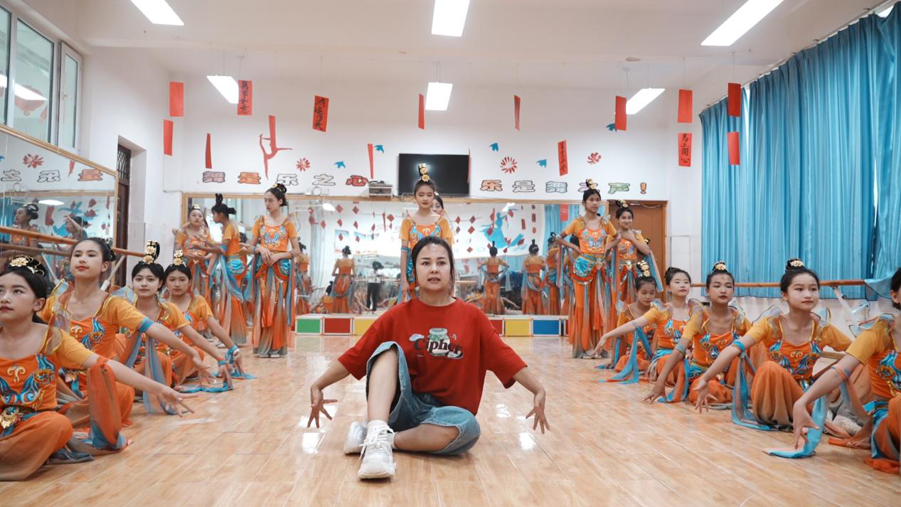 温宿县第五中学小学六年级音乐老师再努热木·图尔荪指导学生排练《龟兹乐舞》(赵新昌 摄)