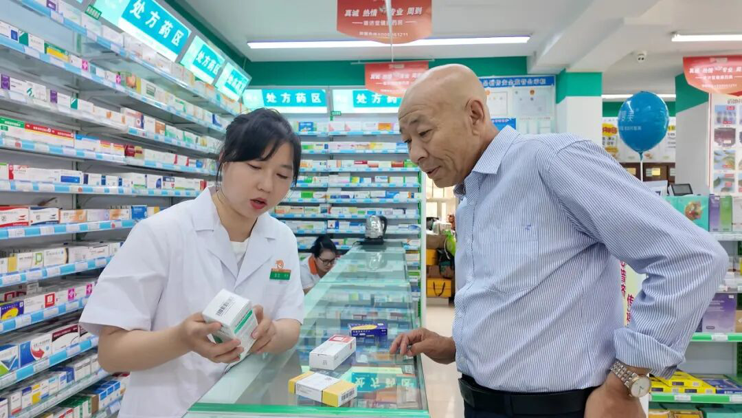 工作人员为市民讲解集采药品政策(上官新宇 摄)