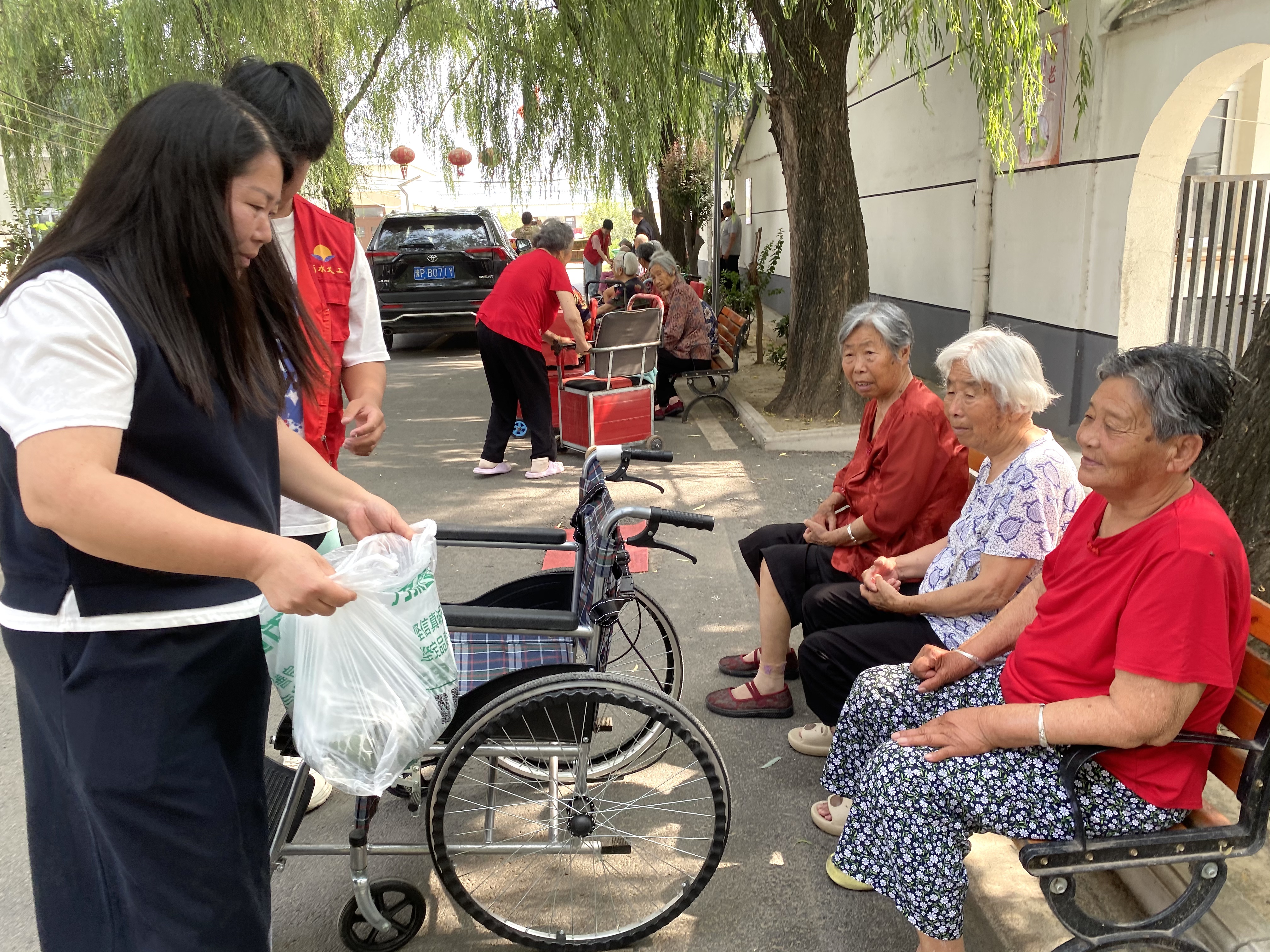 爱心志愿者现场给老人们分发煮热的粽子(赵永昌 摄)
