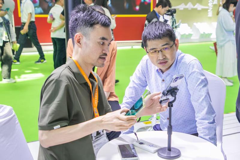 2025年消博会期间,东方市委副书记欧阳华(右)到东方锦达堂木作展台参观指导(吉林 摄)