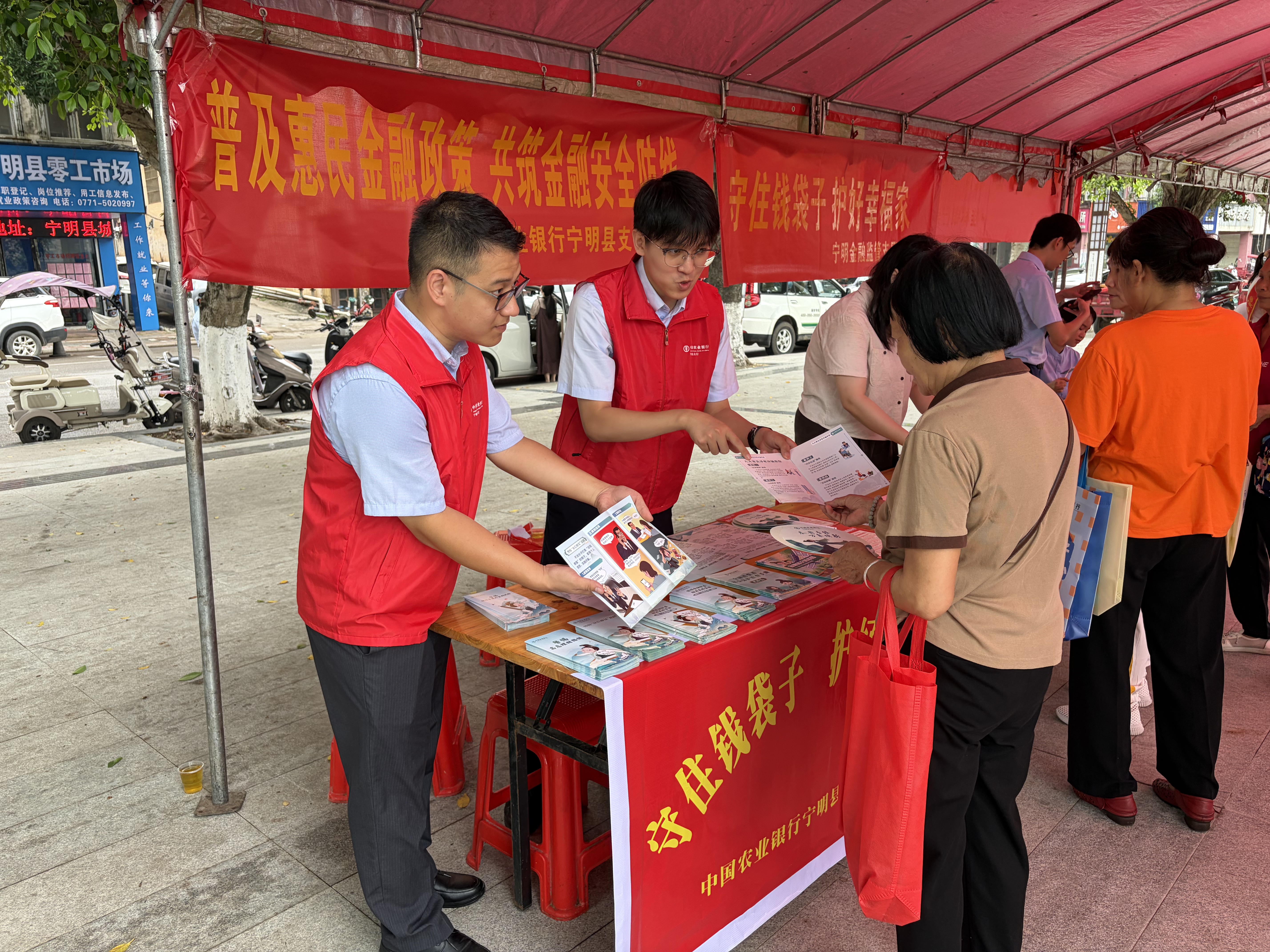 中国农业银行广西宁明县支行组织青年大学生志愿者深入社区开展宣传活动场景(李茂臣 摄)