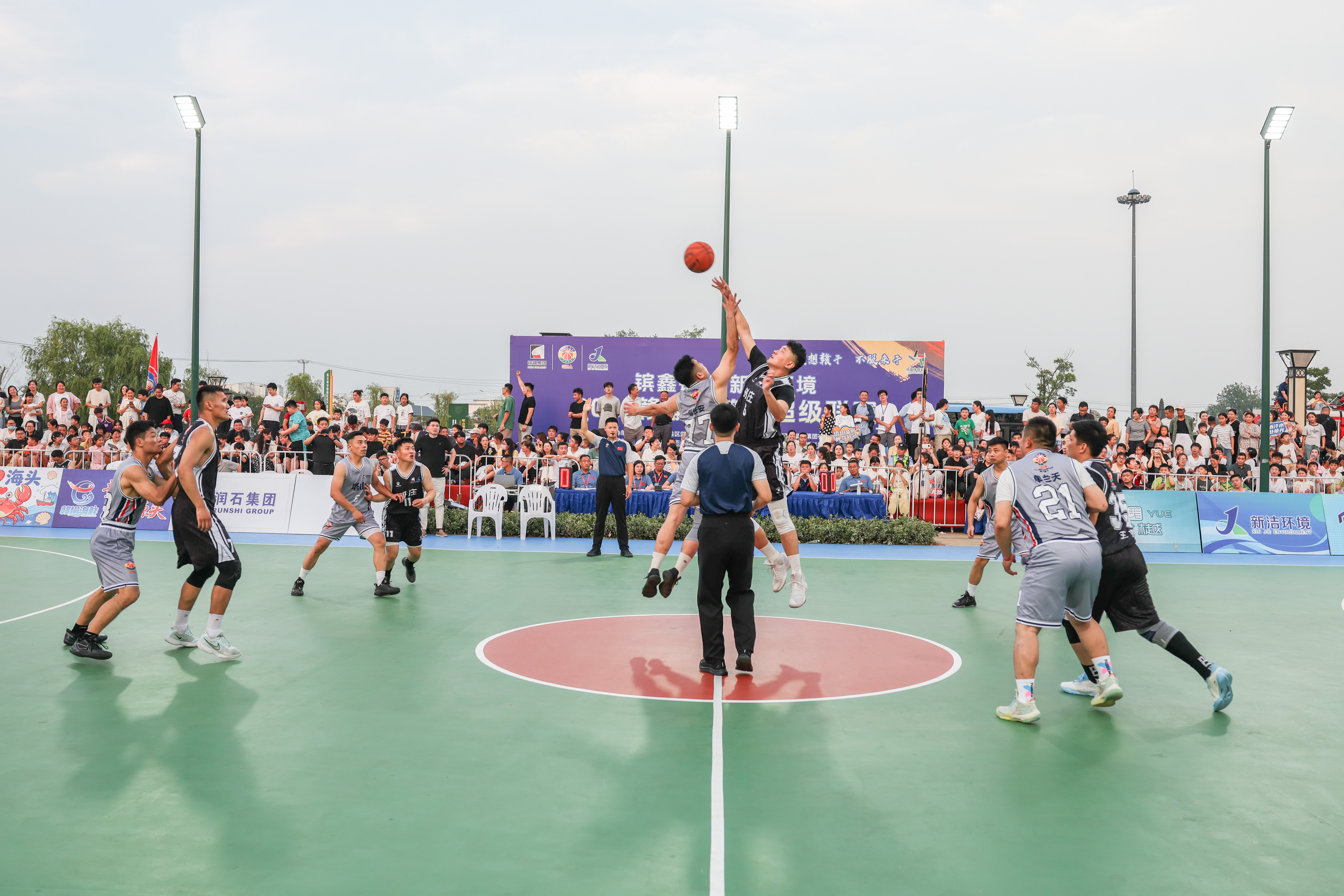2026年7月4日晚,在江苏省连云港市赣榆区塔山镇计斤门广场篮球场,参赛球员在比赛中争球。(司伟 摄)